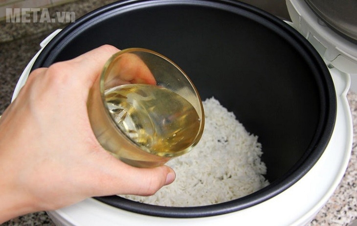 Đổ nước vào gạo để nấu cháo